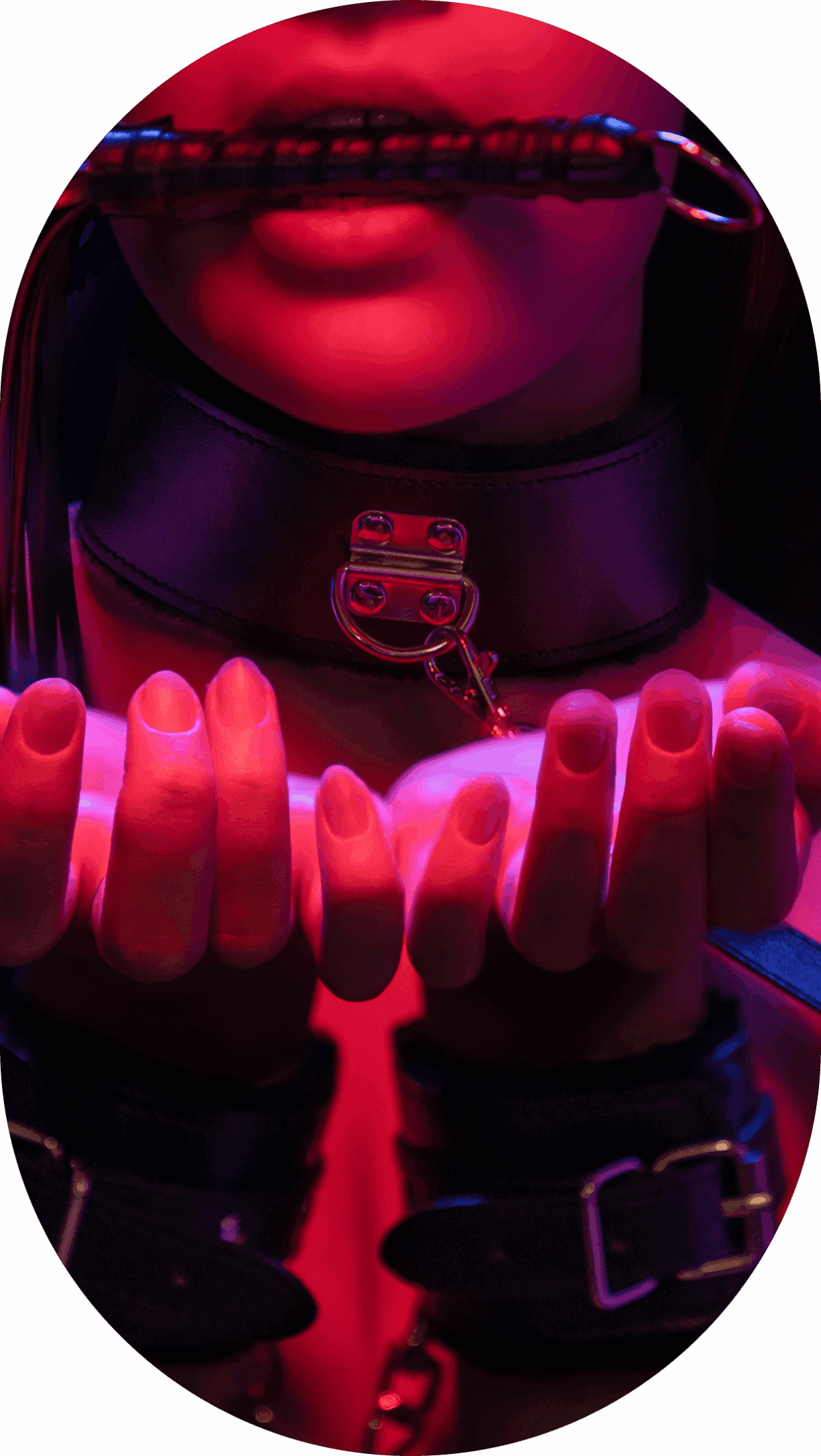 Woman wearing collar and gag holds hands up.