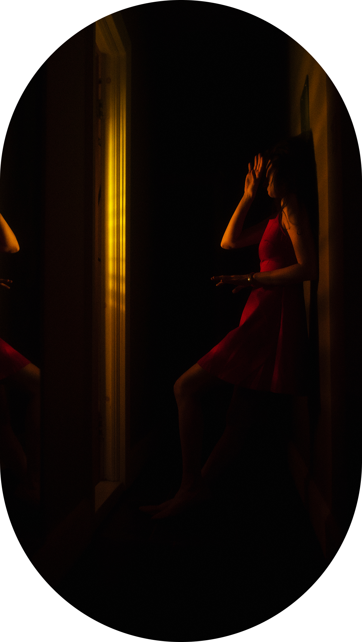 Person in dark hallway with yellow light.