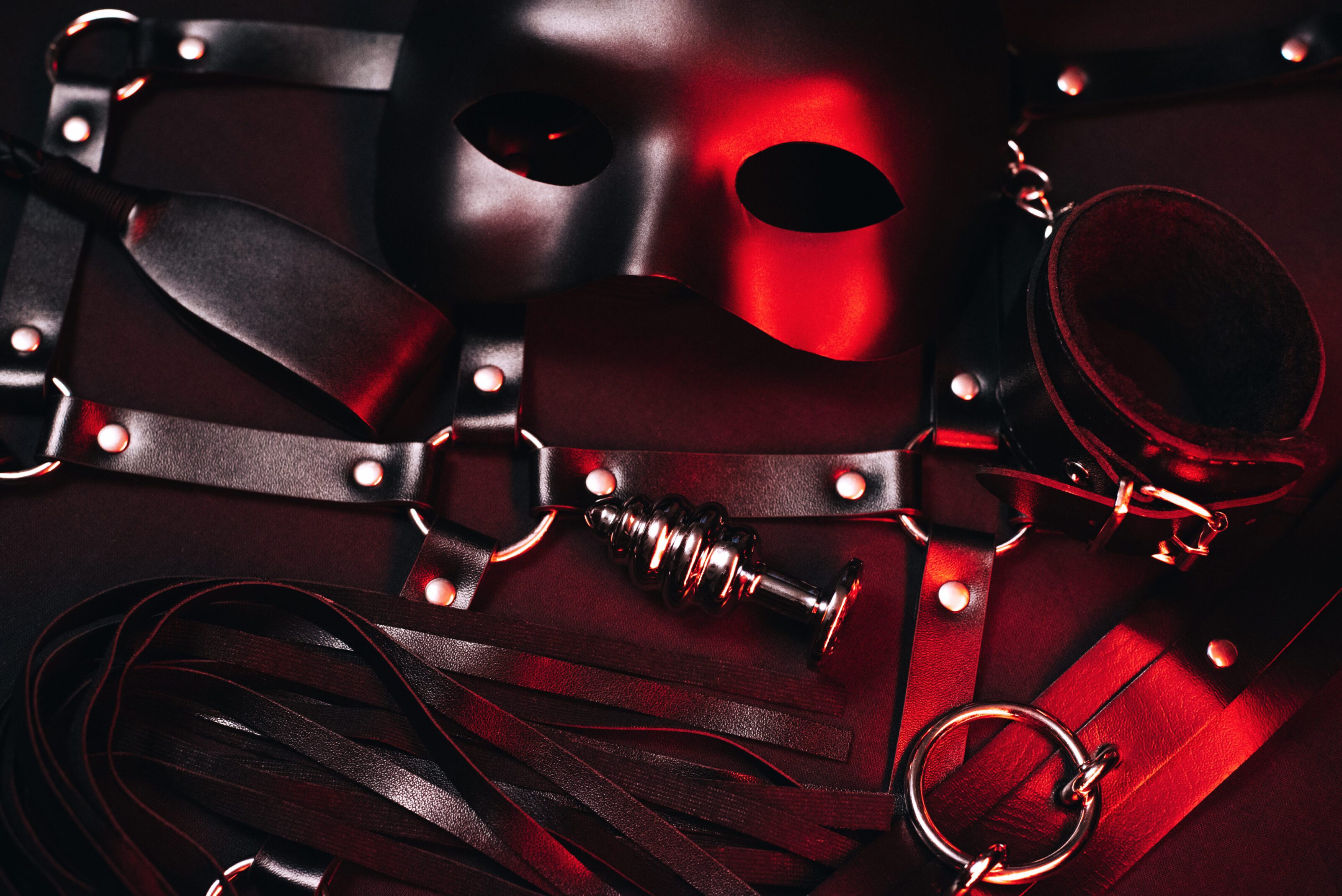 Black mask and leather restraints on display.