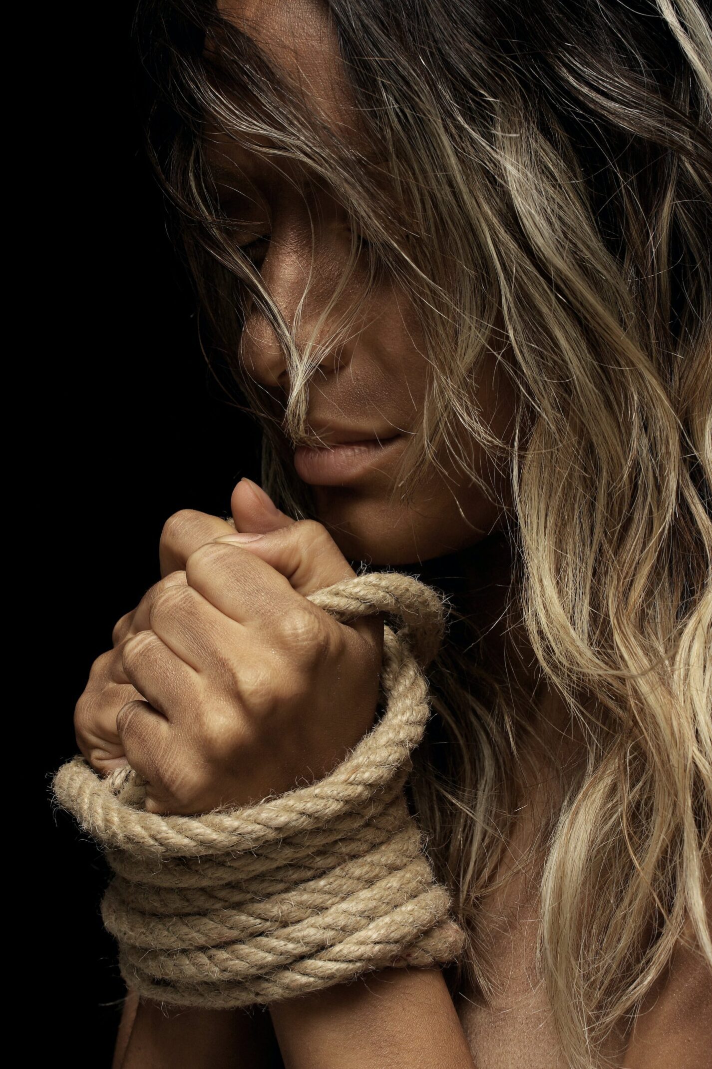 Person with hands bound by rope.